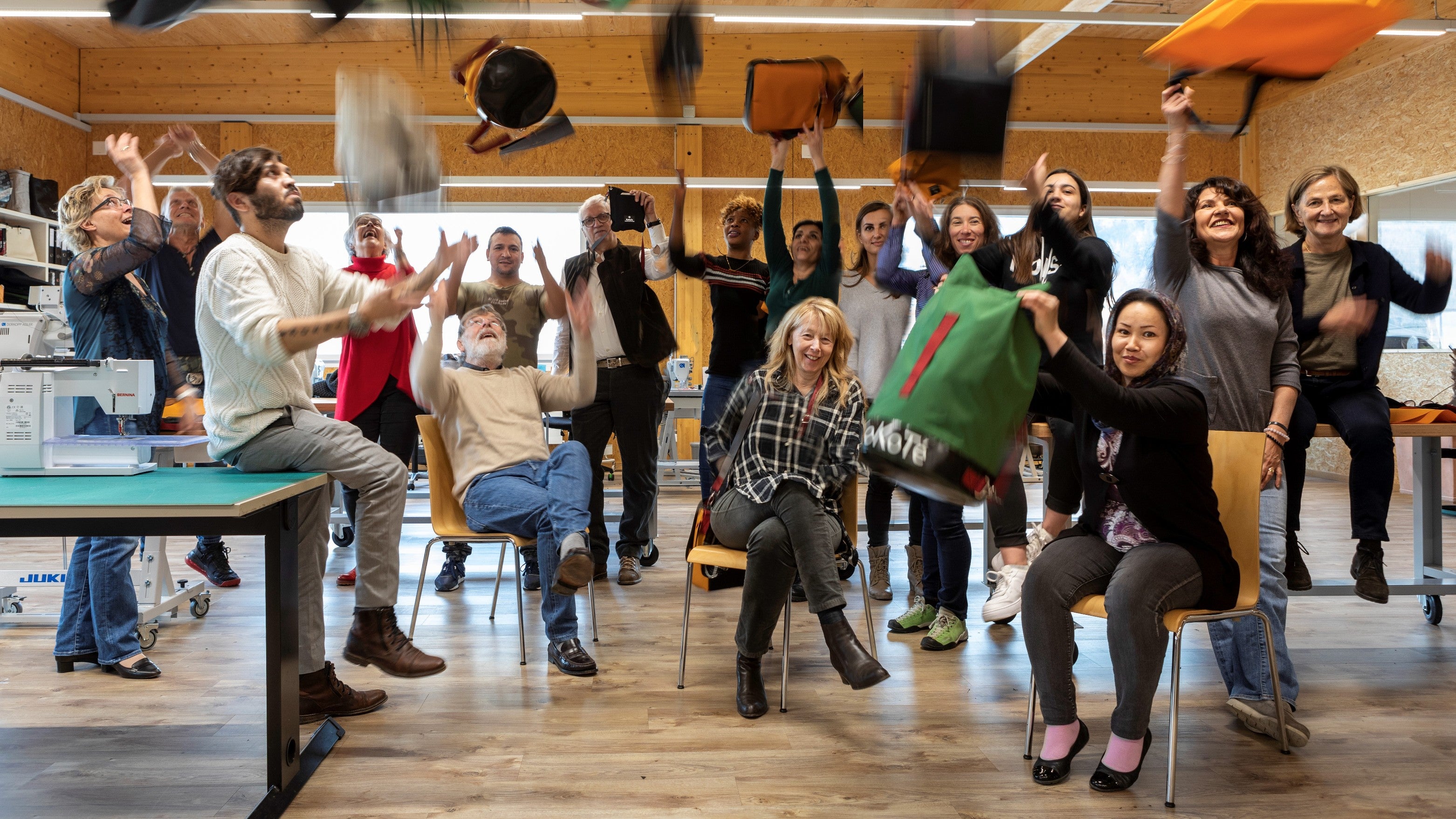 Das Team von KoKoTé wirft die KoKoTé-Taschen in die Luft in der Manufaktur.